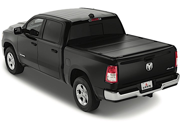 LEER HF350M hard folding tonneau cover on a pickup bed: black hard tri-fold cover closed over a black pickup bed, rear three-quarter view