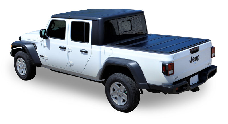 LEER HF650M hard folding tonneau cover on a pickup bed: black hard folding cover closed flat over the bed of a white pickup with a black top