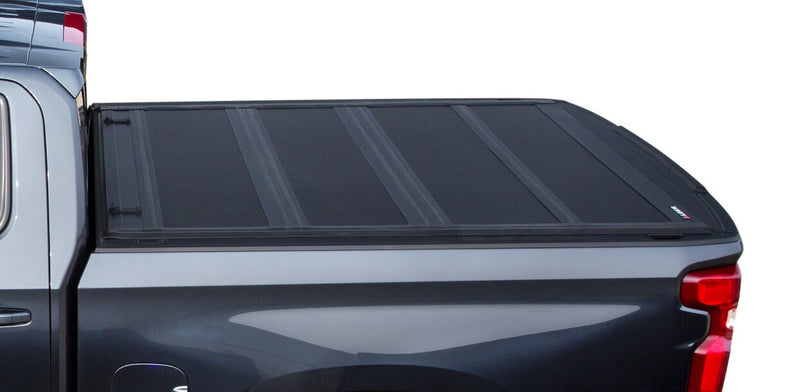 LEER HF650M hard folding tonneau cover closed flat over a pickup bed, side view from cab to tailgate