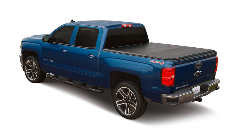 LEER Latitude soft folding tonneau cover on a pickup bed: black soft folding cover closed flat over the bed of a blue pickup (tow hitch accessory shown, not included)