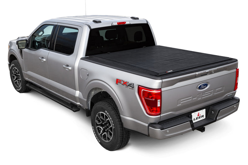 LEER SR250 soft roll-up tonneau cover on a pickup bed: silver pickup with a black soft roll-up cover closed over the bed, rear three-quarter view