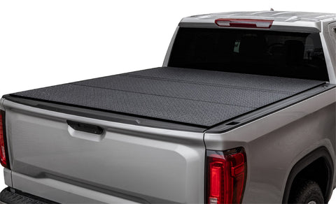 LOMAX Hard Tri-Fold tonneau cover: silver pickup on white, tri-fold closed, black diamond-pattern textured finish