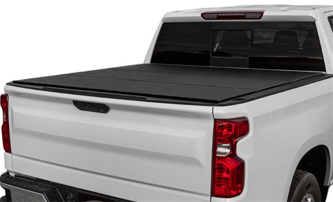 LOMAX Hard Tri-Fold tonneau cover: white pickup on white, tri-fold closed, textured black aluminum urethane