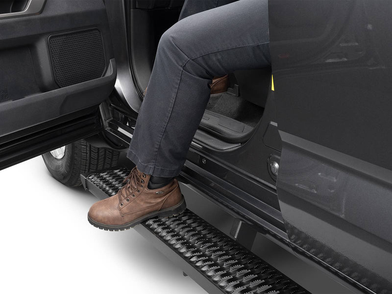 N-Fab Growler Fleet side steps in textured black, boot on the step at an open door, on a Toyota Tundra