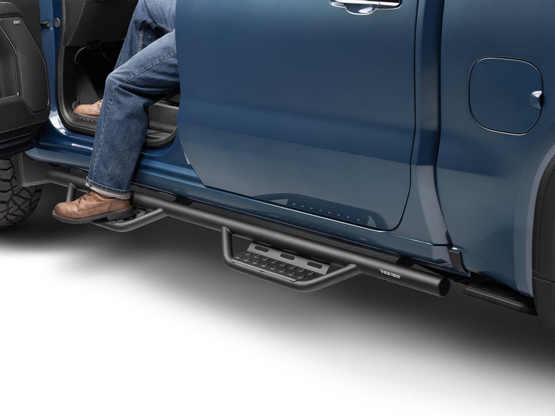N-Fab Nerf Step RS step bars in textured black, boot on the step at an open door