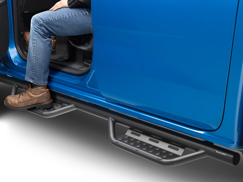 N-Fab Nerf Step RS step bars in textured black, boot on the step at an open door