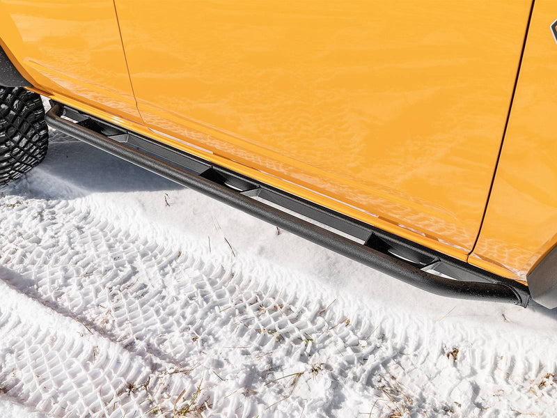N-Fab TrailSlider step system in textured black, low view, installed along the rocker in snow, on a Ford Bronco