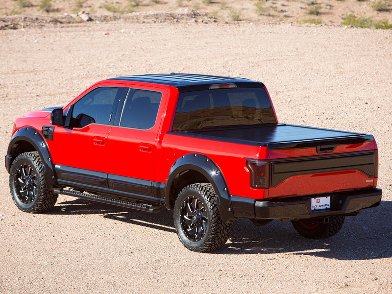 Pace Edwards BedLocker: black retractable cover fully closed on a red customized pickup in the desert