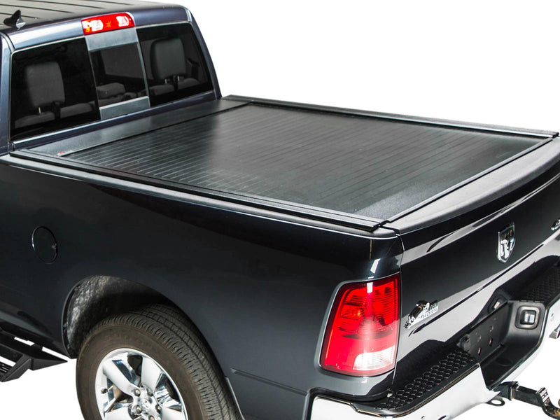 Pace Edwards BedLocker: black retractable cover fully closed on a black pickup bed, rear three-quarter studio view