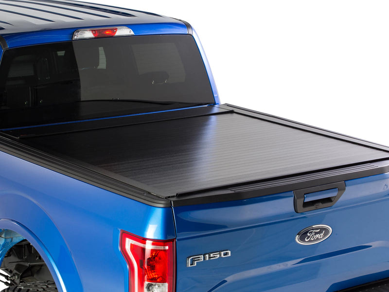 Pace Edwards BedLocker: black retractable cover fully closed on a blue pickup bed, rear three-quarter view