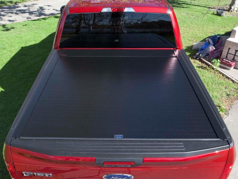 Pace Edwards BedLocker: overhead view of a black retractable cover fully closed on a red pickup bed