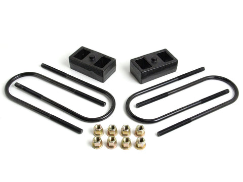 ReadyLIFT 2" Rear Block Kit, on a studio background: two black 2" cast iron rear lift blocks with U-bolts and nuts