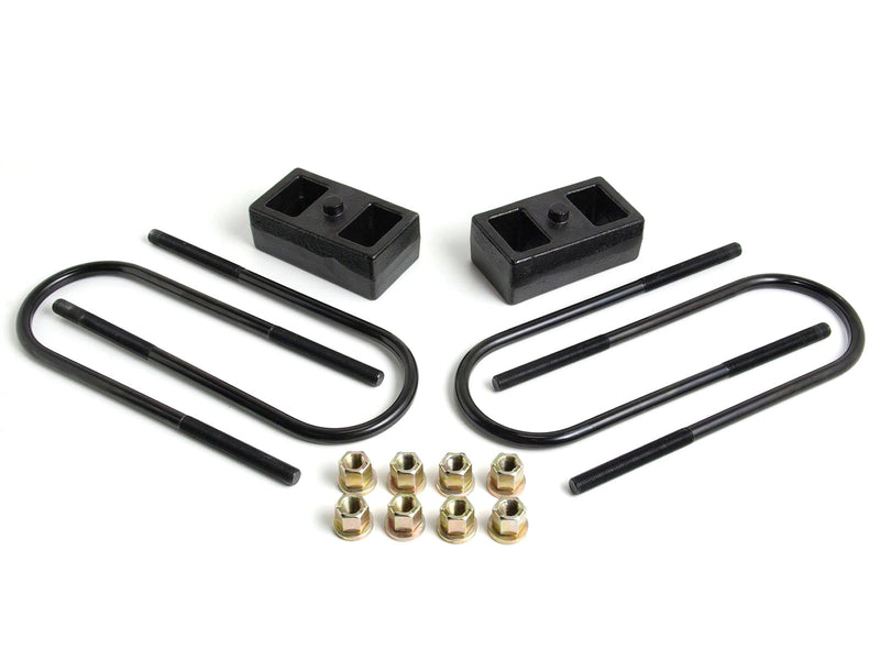 ReadyLIFT 2" Rear Block Kit, on a studio background: two black 2" cast iron rear lift blocks with U-bolts and nuts