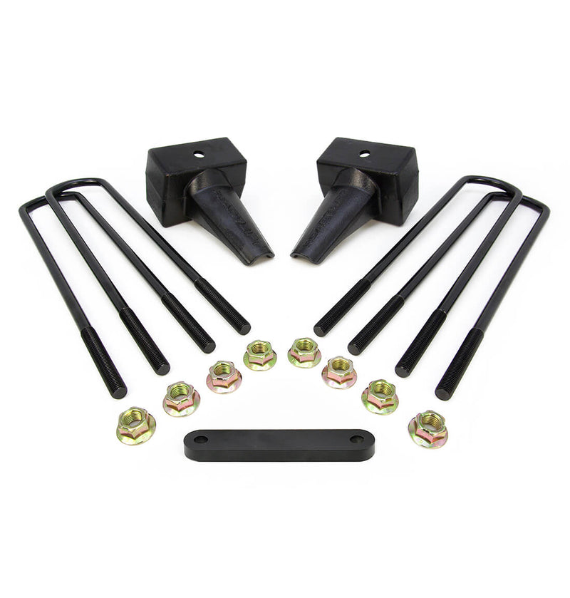 ReadyLIFT Block Kit, full kit on a studio background: two black tapered 4" rear lift blocks with four square U-bolts, gold nuts and a spacer plate on white