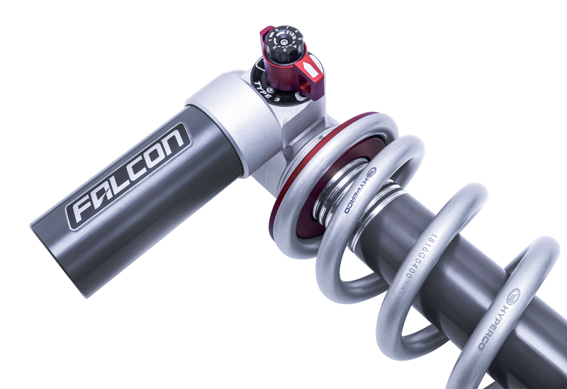 Close-up of the ReadyLIFT Coilover Front Lift Kit: close-up of a Falcon 3.3 coilover with Hyperco-marked silver spring and red adjuster on black