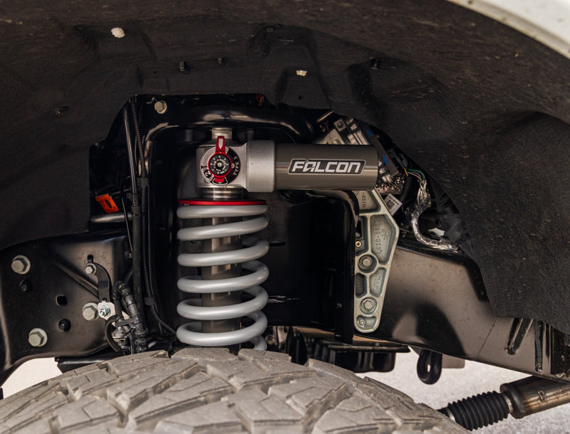 ReadyLIFT Coilover Front Lift Kit on a vehicle: Falcon 3.3 coilover with silver spring and red adjuster installed in a Super Duty front wheel well