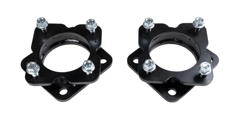 ReadyLIFT Leveling Kit, full kit on a studio background: two black strut spacers with studs and nuts on a black background