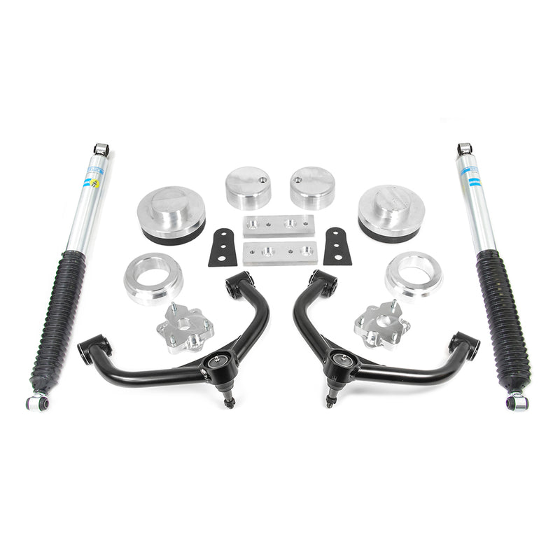 ReadyLIFT SST Lift Kit, full kit on a studio background: aluminum spacers, black upper control arms, brackets and two blue-and-yellow Bilstein rear shocks on white