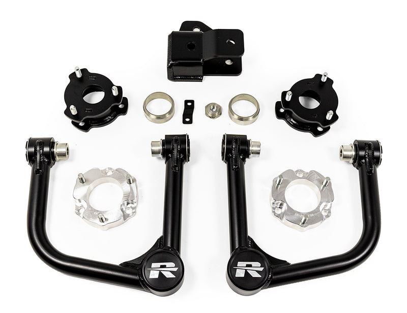ReadyLIFT SST Lift Kit, full kit on a studio background: two black tubular upper control arms, black and aluminum spacers, rings and a bracket on white