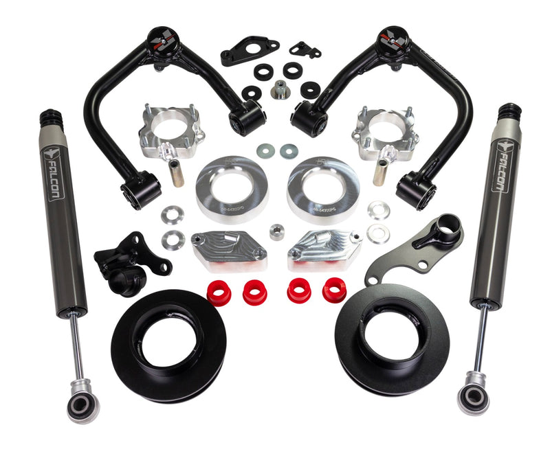 ReadyLIFT SST Lift Kit, full kit on a studio background: two black upper control arms, aluminum and black spacers, brackets, red bushings and two gray Falcon rear shocks on white