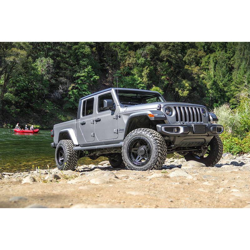 ReadyLIFT Terrain Flex 4-Arm Lift Kit installed on a Jeep Gladiator: A gray lifted Jeep Gladiator parked by a river with a distant raft behind
