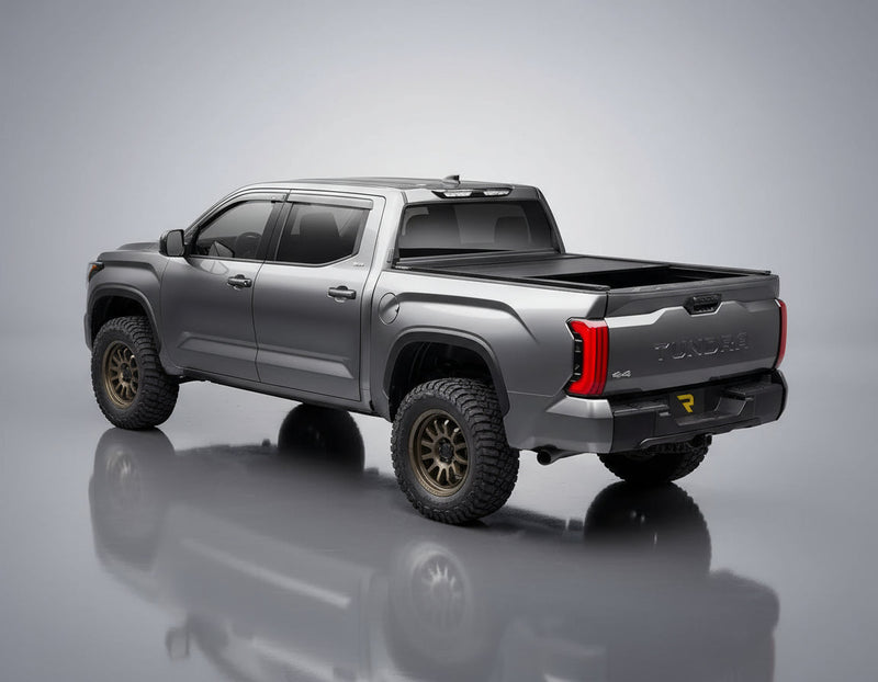 Retrax EQ cover partly open on a gray pickup in a studio, rear three-quarter view