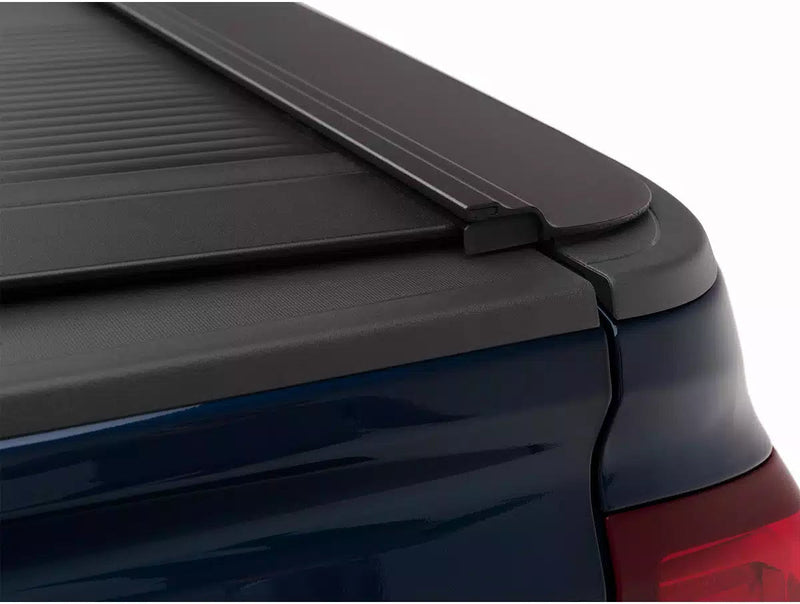 Closed RetraxONE MX rail end cap meeting the tailgate corner on a dark blue pickup
