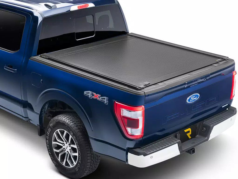 RetraxONE XR fully closed on a blue pickup, rear three-quarter view on white
