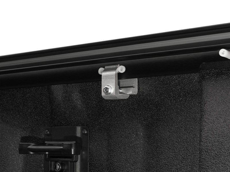 Aluminum clamp holding the side rail to the bed wall, no-drill install