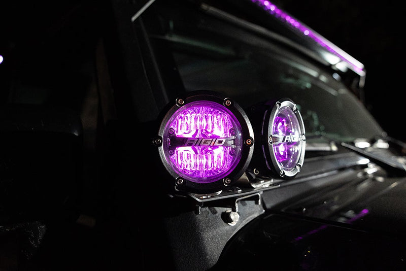 Rigid 360-Series PRO 4" Pair installed on a vehicle: two round LED pods on an A-pillar mount glow purple against a dark vehicle at night