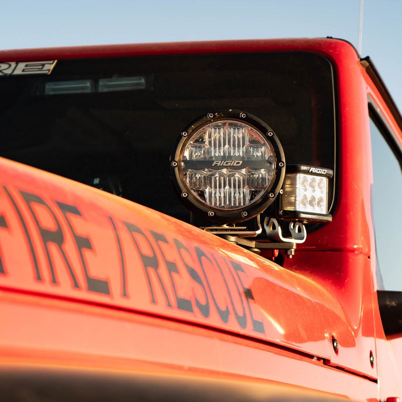 Rigid 360-Series PRO 6" Pair installed on a vehicle: A 6" round LED light and a small cube light sit on the cowl of a red fire rescue vehicle