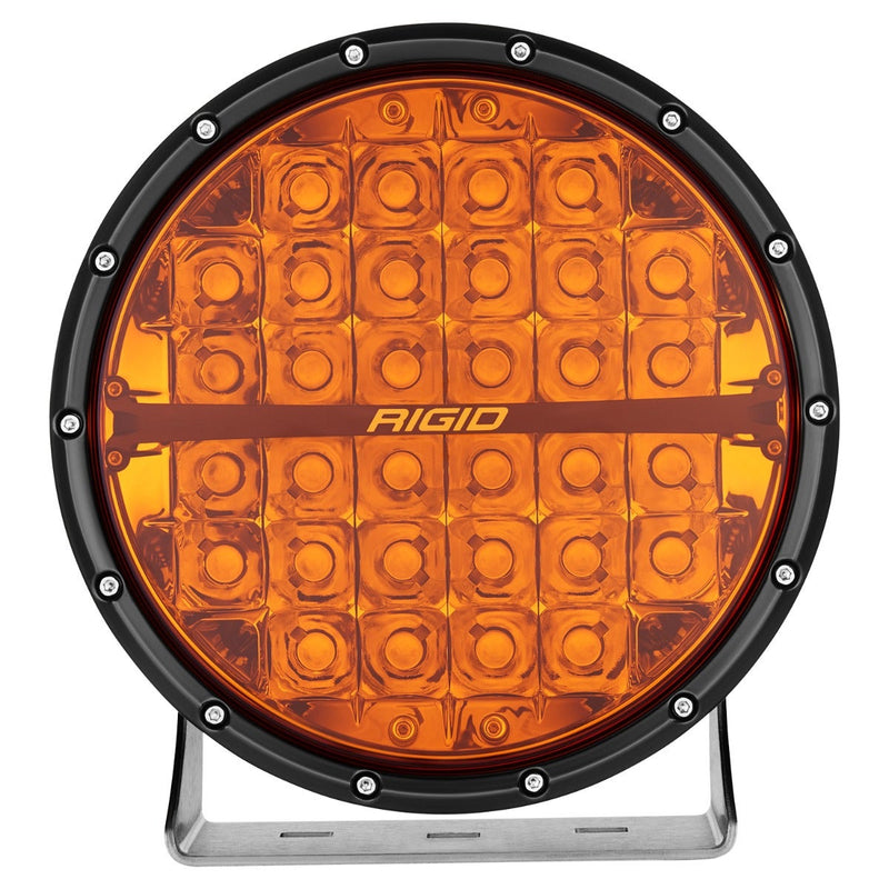 Rigid 360-Series PRO 9" on a studio background: A black 9" round LED light with an amber lens and polished bracket, front on against white