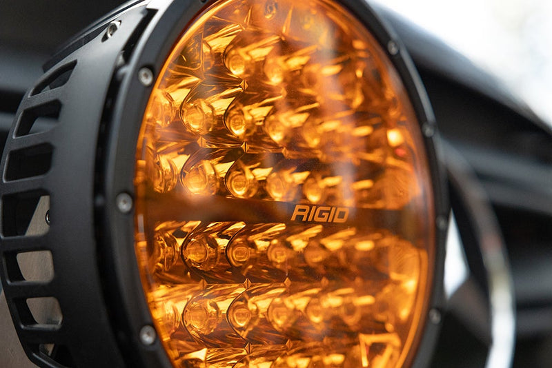 Close-up of the Rigid 360-Series PRO 9": A close-up shows the amber lens and finned black housing of a large round LED light