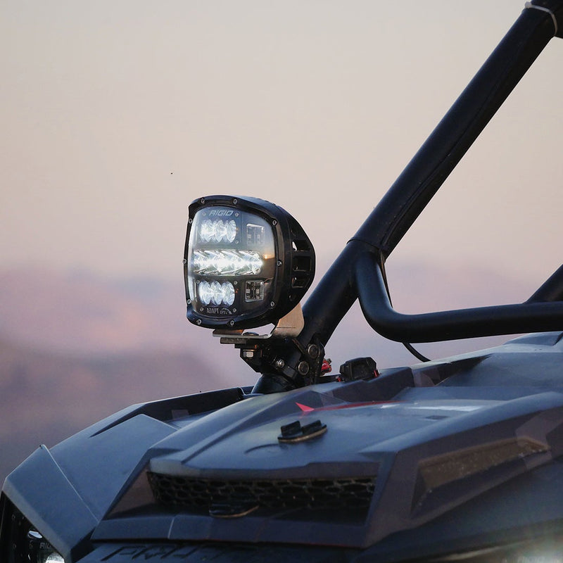 Rigid Adapt XP installed on a vehicle: an Adapt XP light is mounted on the roll cage pillar of a side by side at dusk
