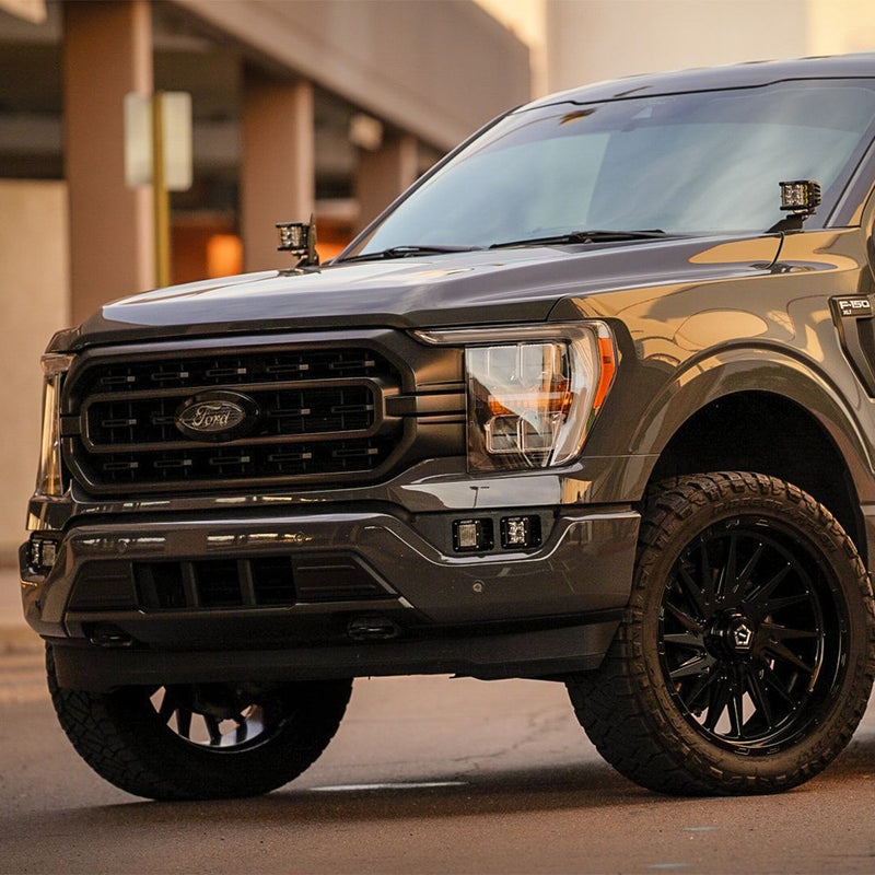 Rigid Dual Fog Light Kit installed on a Ford F-150: gray Ford F-150 front view with square pods in both fog pockets and A-pillar pods