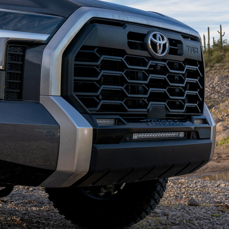 Rigid SAE Fog Light Kit installed on a Toyota Tundra: front view of a gray Toyota Tundra TRD grille with a light bar in the lower bumper