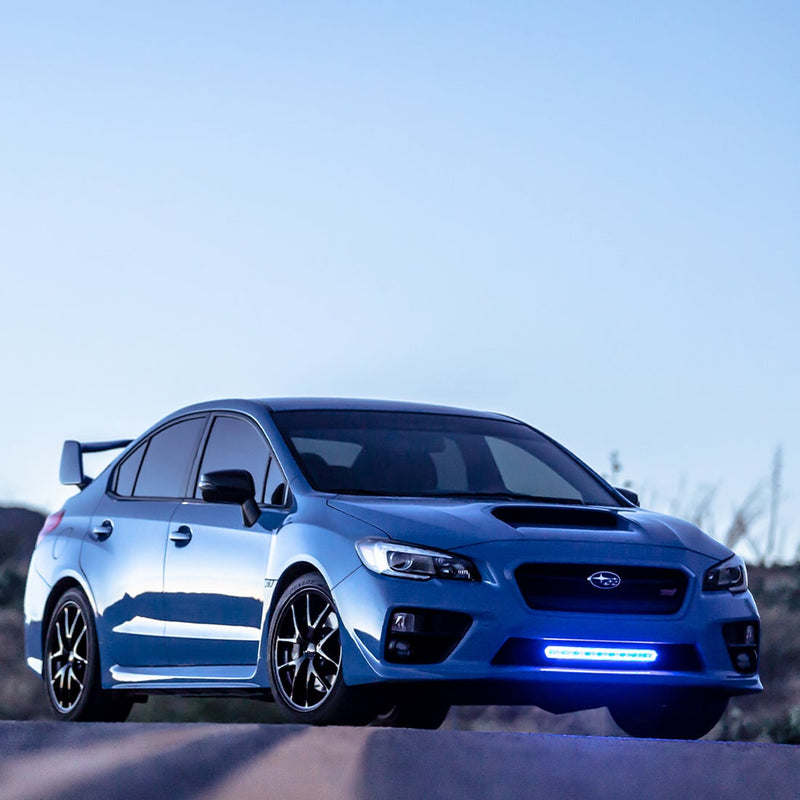 Rigid SR-L Series 20" LED bar mounted in the lower grille of a blue sedan, halo ring lit blue at dusk