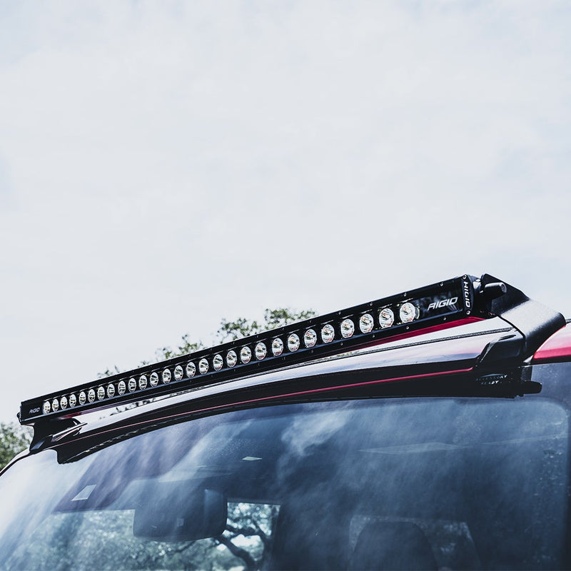 Rigid SR Spot/Flood 40" Bar Roof Line Light Kit installed on a Ford Bronco: A Rigid SR-Series light bar mounted along the roof line of a red Bronco