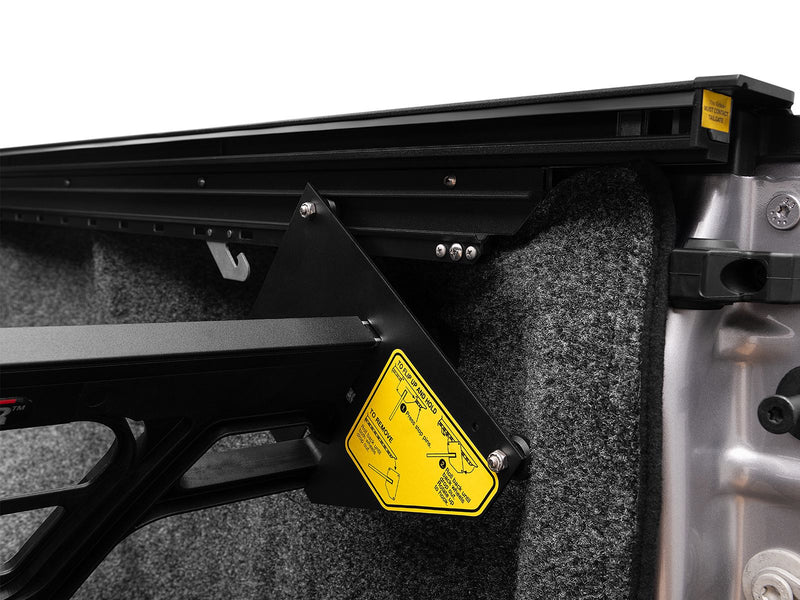 Roll-N-Lock Cargo Manager foot seated in the bed rail channel beside the wheel well