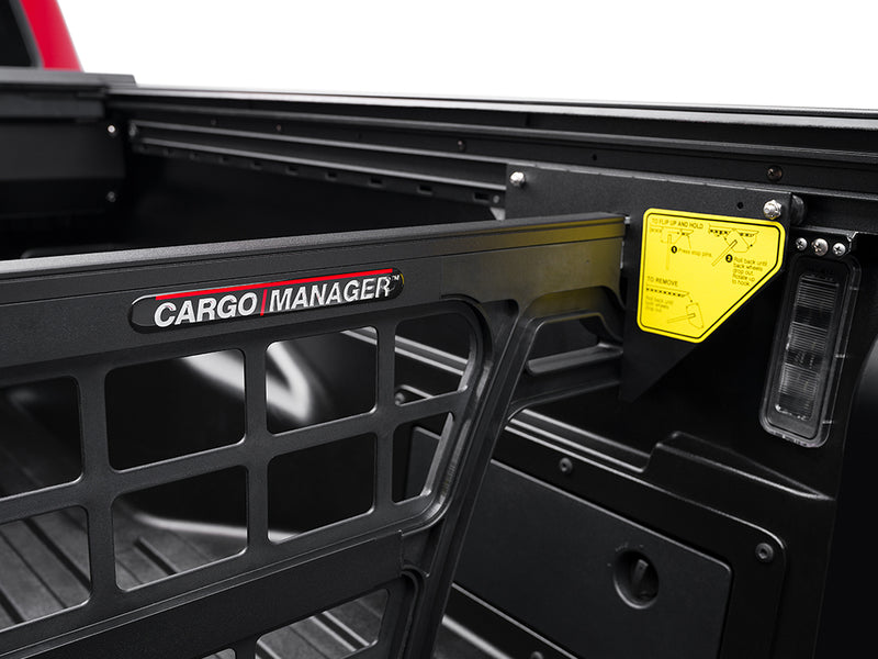 Roll-N-Lock Cargo Manager upper rail with the Roll-N-Lock name plate and its yellow operating label