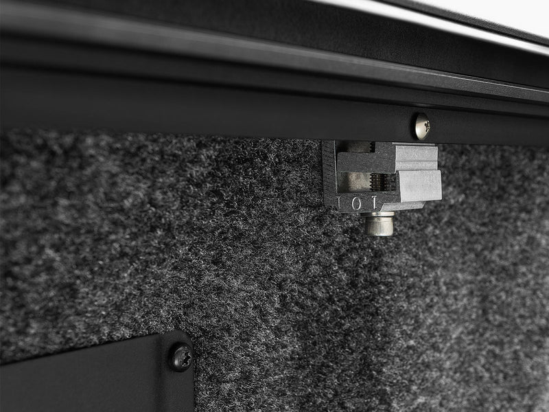 Roll-N-Lock E-Series underside mounting block sitting over a carpeted bed liner