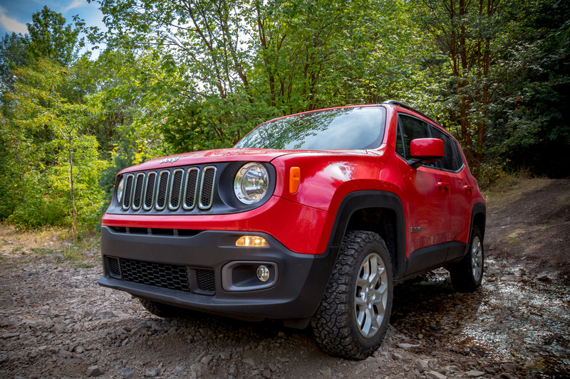 Red Jeep Renegade with the TeraFlex 1.5" Performance Spacer Lift Kit installed, on a muddy trail