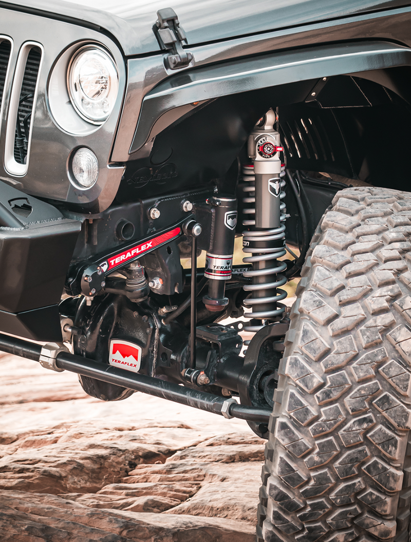 TeraFlex Pneumatic Sway Bar on a Jeep Wrangler: JK Wrangler front corner showing a TeraFlex sway bar arm and actuator, Falcon coilover and TeraFlex diff cover on slickrock