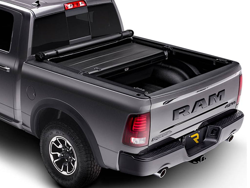 Soft tonneau cover rolled up against the front hard section, leaving most of the bed open