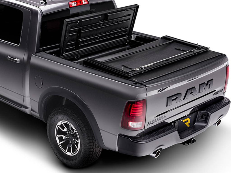Cover rolled forward with the front hard section tilted up toward the cab, bed open