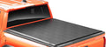 Lo Pro soft roll-up tonneau cover closed flat over the bed of an orange pickup, rear three-quarter view