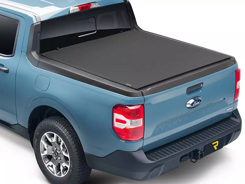 Soft roll-up tonneau cover closed on a blue compact pickup, rear three-quarter view