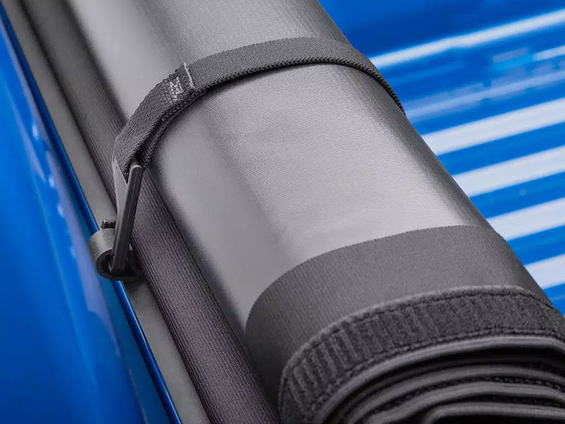 Close-up of the rolled cover held by its hook-and-loop storage strap