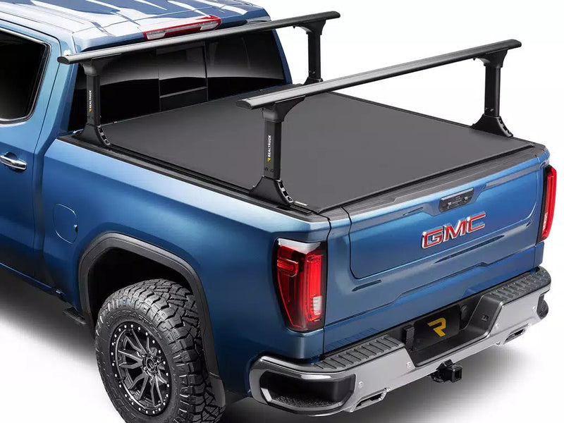 Pro X15 TS soft roll-up tonneau cover closed over the bed of a blue pickup, rear three-quarter view; the bed rack is shown for illustration and is sold separately