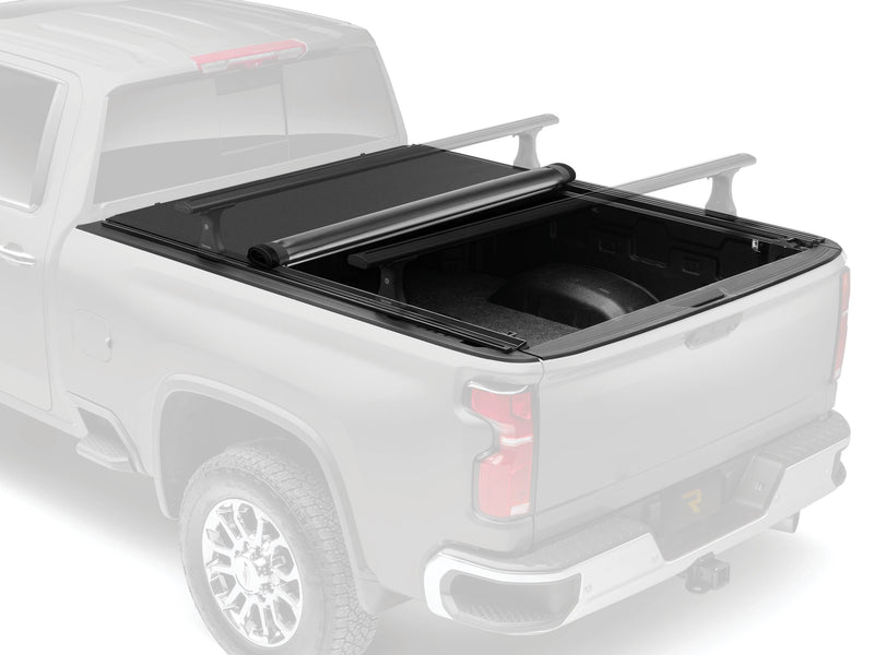 Pro X15 TS soft roll-up tonneau cover partly rolled toward the cab on a faded pickup, with its T-slot rails and the rear of the bed open; the roof-style crossbars are an accessory sold separately